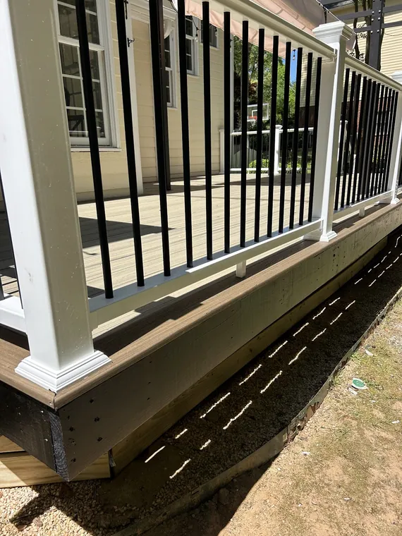 Two story deck with white railing above a screened porch, Griffin GA