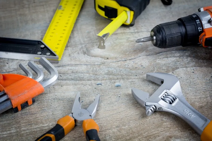 Hand tools laid out for a plumbing repair